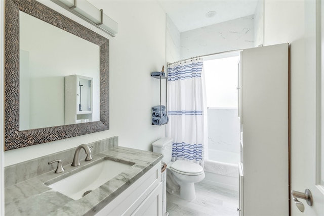 full bathroom featuring vanity, shower / bath combo with shower curtain, toilet, and wood-type flooring