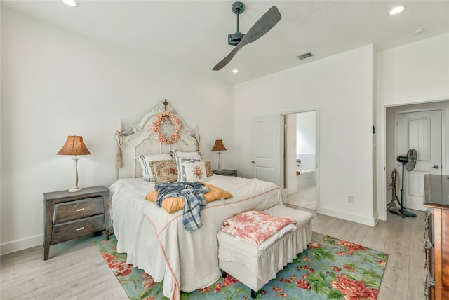 bedroom with ceiling fan, connected bathroom, and light hardwood / wood-style floors