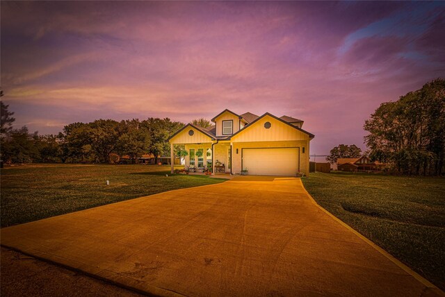 view of front of home featuring a garage and a yard