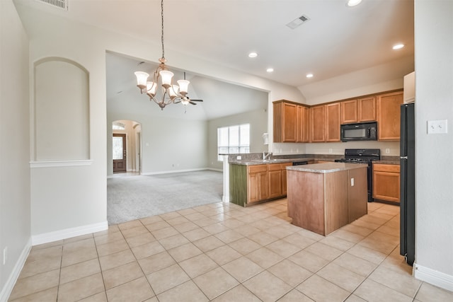 kitchen featuring light tile patterned floors, black appliances, sink, a kitchen island, and decorative light fixtures