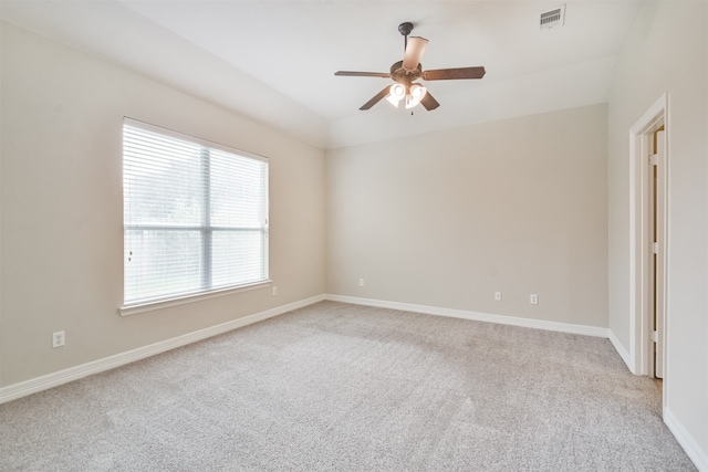 carpeted spare room featuring ceiling fan and plenty of natural light