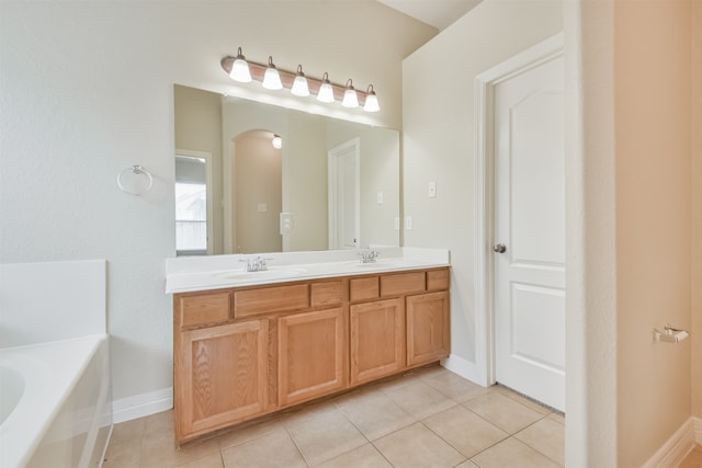 bathroom with dual vanity, tile patterned floors, and a bathtub