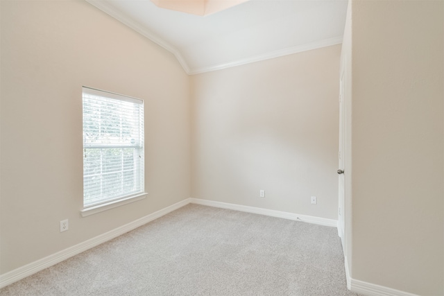 carpeted empty room featuring ornamental molding and vaulted ceiling