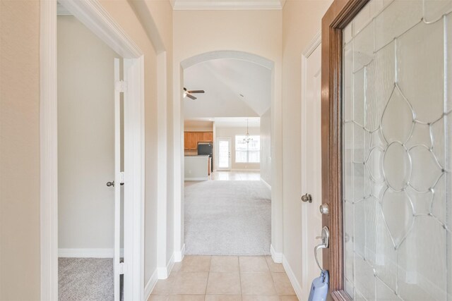 hall with ornamental molding and light carpet