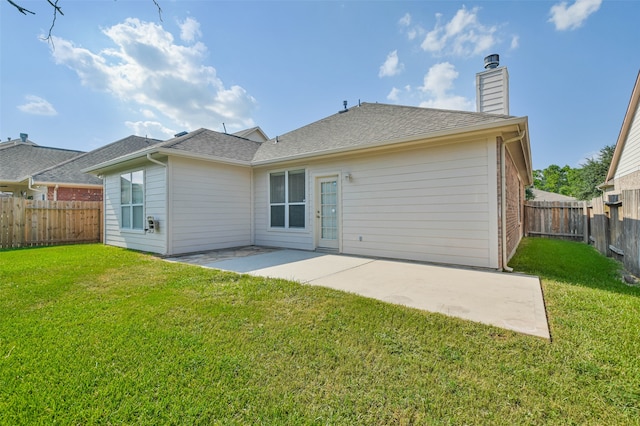 back of house with a patio area and a lawn