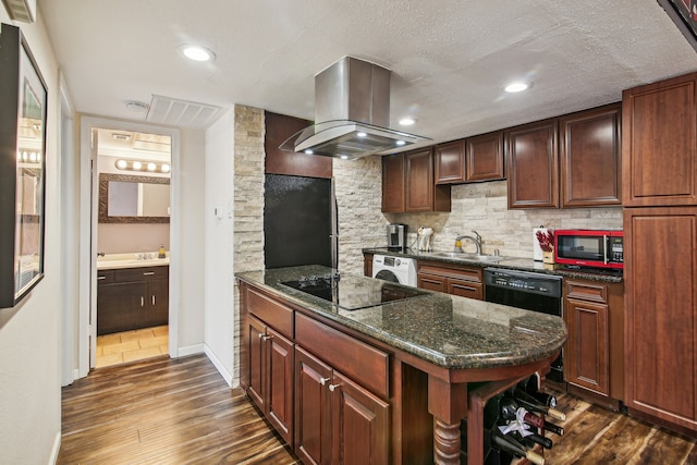 kitchen with black appliances, a textured ceiling, island exhaust hood, dark wood-type flooring, and dark stone countertops