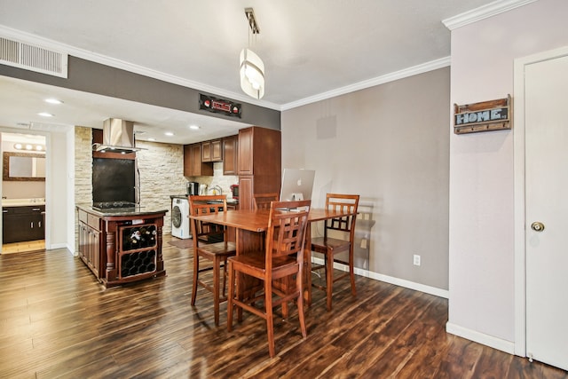 dining room with dark hardwood / wood-style floors, washer / dryer, and ornamental molding