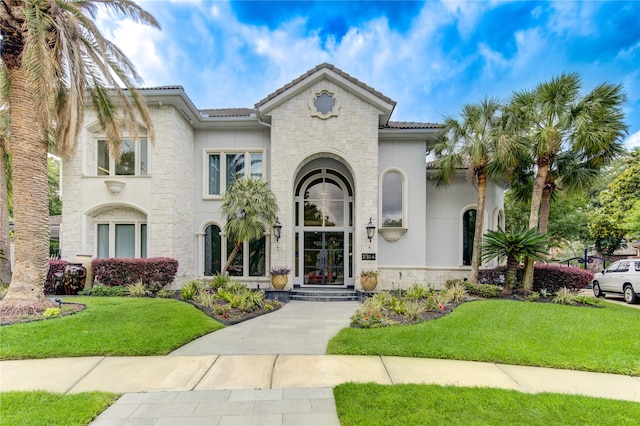 mediterranean / spanish-style house with a front lawn