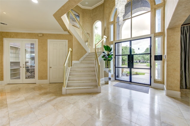 interior space featuring crown molding, a towering ceiling, and french doors