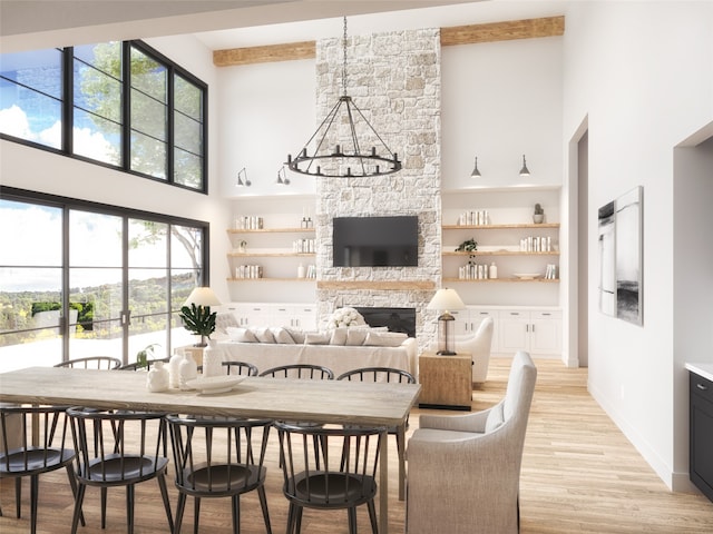 dining area featuring a stone fireplace, a wealth of natural light, light hardwood / wood-style flooring, and a high ceiling