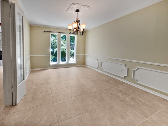 empty room featuring ornamental molding, light tile patterned floors, and an inviting chandelier