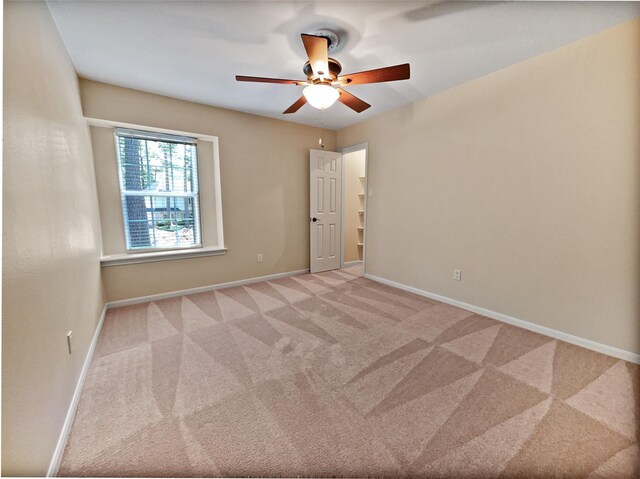 carpeted spare room with ceiling fan