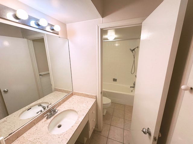 full bathroom with tile patterned flooring, toilet, tiled shower / bath combo, and vanity