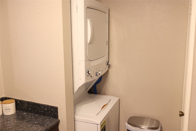 clothes washing area featuring stacked washer and dryer