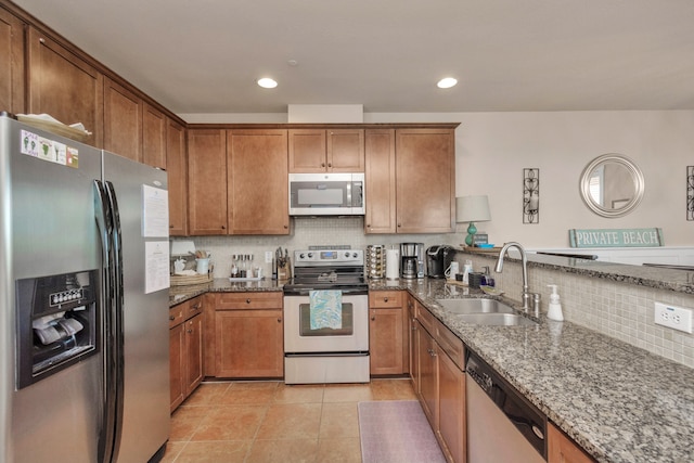 kitchen featuring sink, dark stone counters, and stainless steel appliances