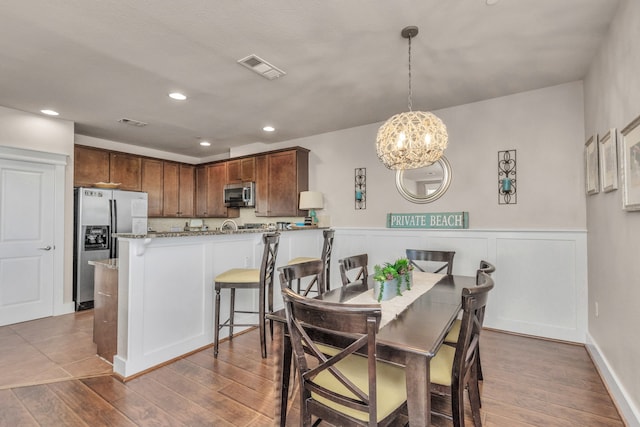 dining room with hardwood / wood-style flooring and a chandelier