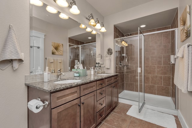 bathroom with dual vanity, walk in shower, and tile patterned floors