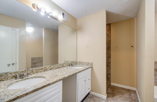 bathroom featuring a textured ceiling and vanity