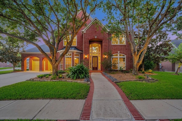 tudor home featuring a garage and a lawn