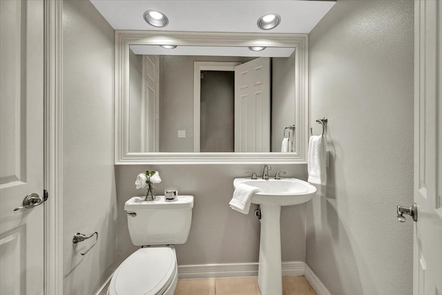 bathroom with sink, toilet, and tile patterned flooring