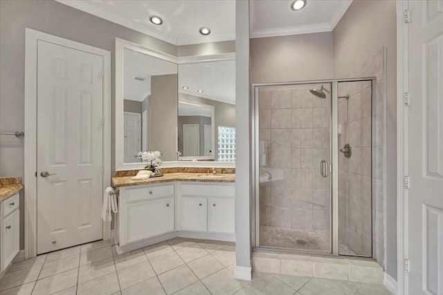 bathroom featuring tile patterned floors, vanity, a shower with shower door, and ornamental molding