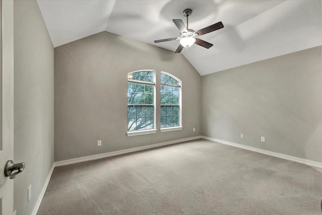 carpeted spare room with ceiling fan and vaulted ceiling