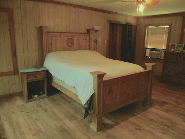 bedroom featuring wood walls, ceiling fan, and hardwood / wood-style floors