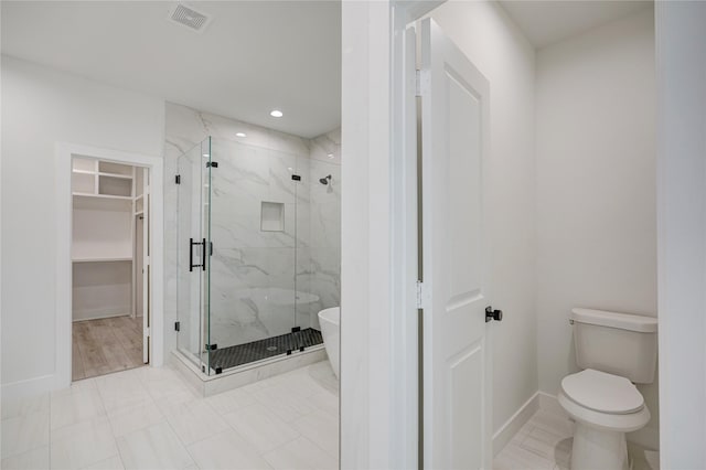 bathroom with a shower with shower door, tile patterned flooring, and toilet