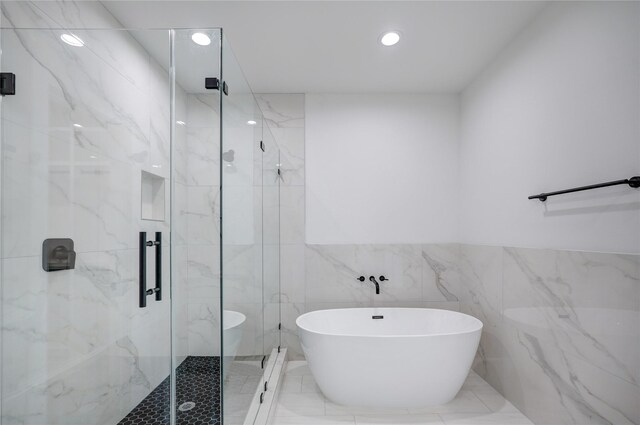 bathroom featuring tile patterned flooring, tile walls, and independent shower and bath