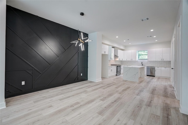 unfurnished living room with light hardwood / wood-style flooring and sink