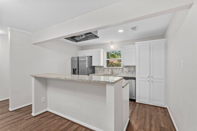 kitchen with appliances with stainless steel finishes, dark wood-type flooring, white cabinets, and backsplash