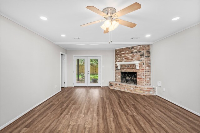 unfurnished living room featuring a fireplace, ceiling fan, crown molding, and dark wood-type flooring