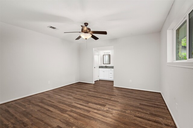 unfurnished bedroom with dark hardwood / wood-style flooring, ensuite bathroom, and ceiling fan