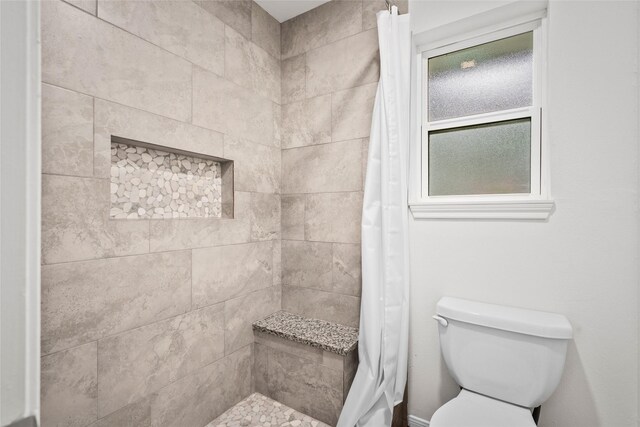 bathroom with toilet and walk in shower