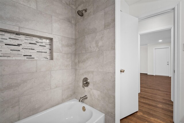 bathroom with tiled shower / bath and hardwood / wood-style floors