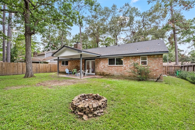 rear view of property featuring a patio and a yard