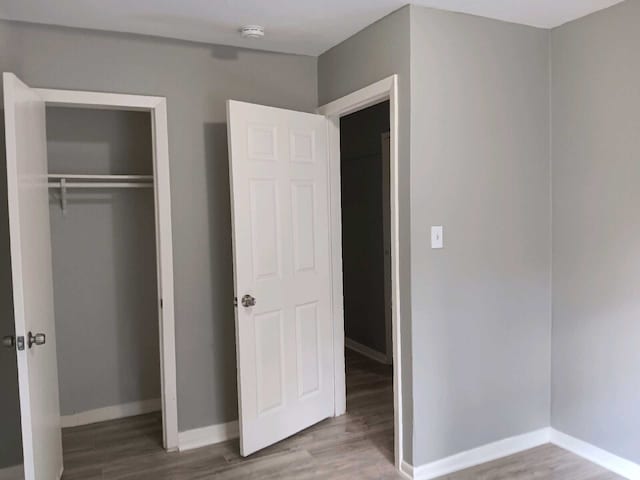 unfurnished bedroom with hardwood / wood-style floors and a closet