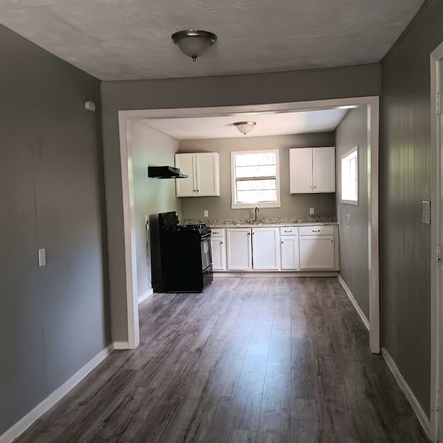 kitchen featuring white cabinetry, dark wood-type flooring, sink, and black range oven