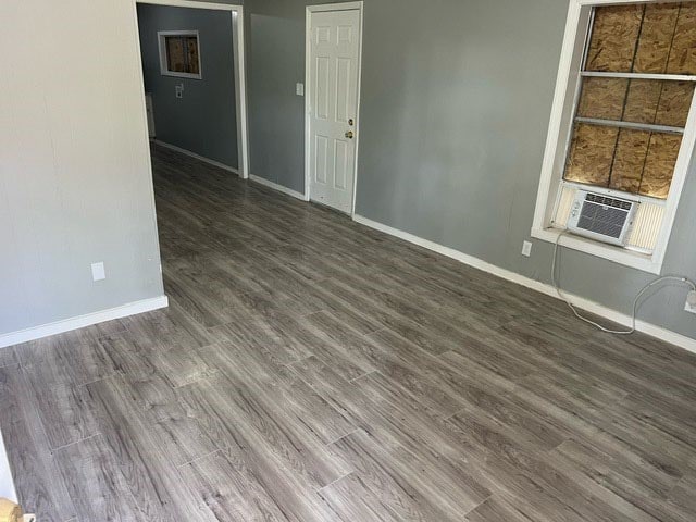 empty room with dark wood-type flooring and cooling unit