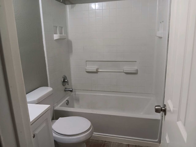 full bathroom with hardwood / wood-style flooring, tiled shower / bath, vanity, and toilet