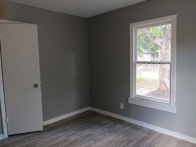 empty room featuring a healthy amount of sunlight and hardwood / wood-style floors