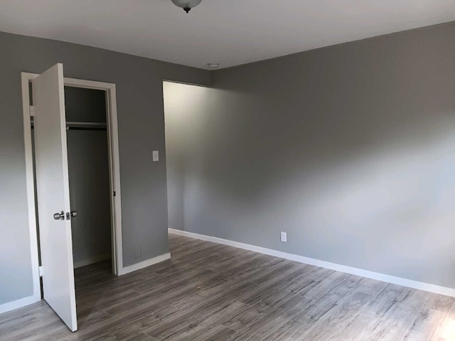 unfurnished bedroom with hardwood / wood-style flooring and a closet