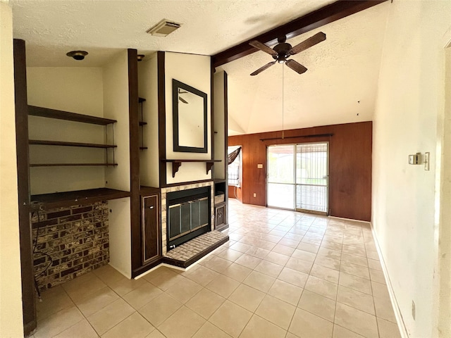 interior space with lofted ceiling with beams, a textured ceiling, ceiling fan, and light tile patterned floors