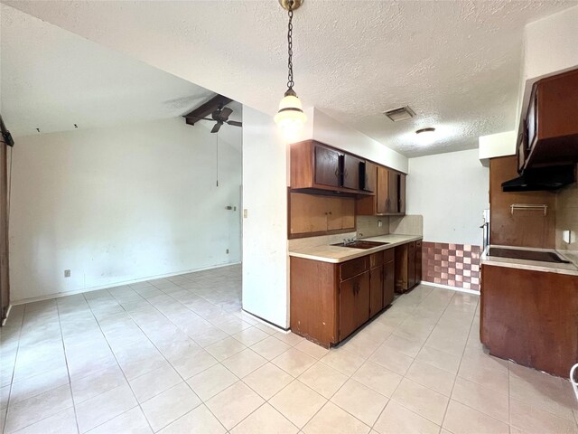 kitchen featuring decorative light fixtures, light tile patterned flooring, ceiling fan, sink, and vaulted ceiling