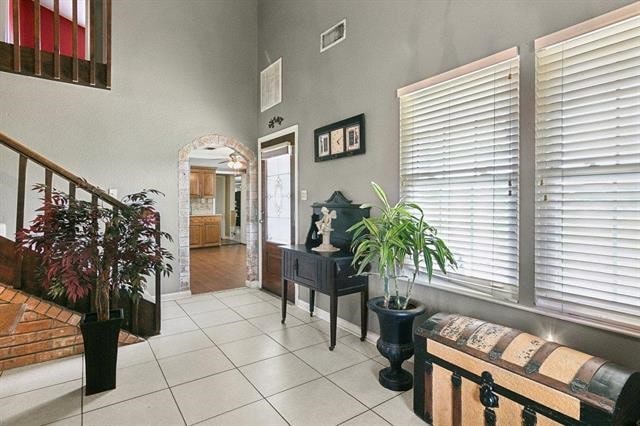 foyer entrance with light tile patterned floors and a high ceiling