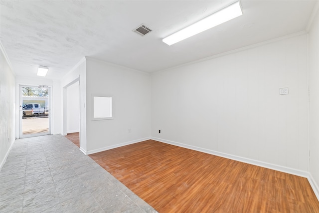 empty room with wood-type flooring and crown molding