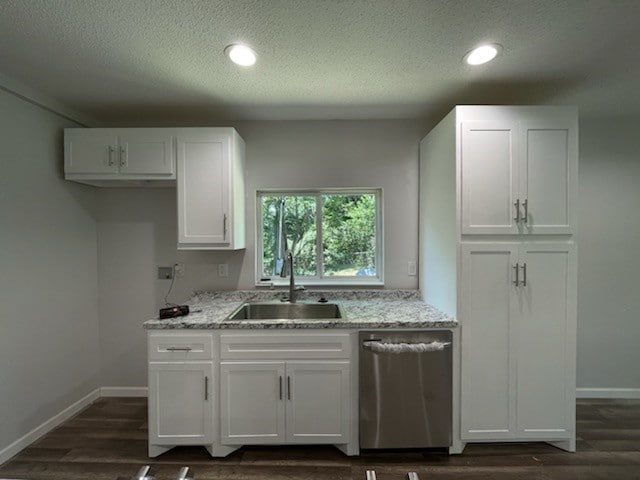 kitchen featuring stainless steel dishwasher, white cabinetry, sink, dark hardwood / wood-style floors, and a textured ceiling