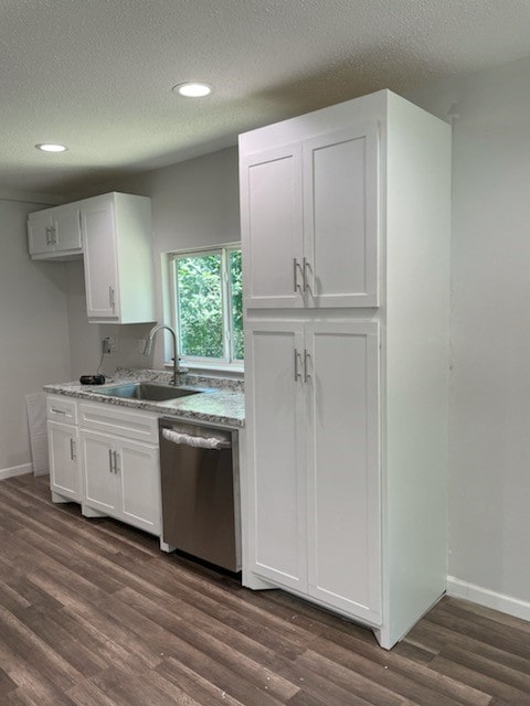 kitchen with sink, stainless steel dishwasher, dark hardwood / wood-style flooring, and white cabinetry