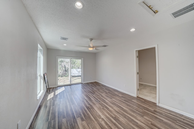 empty room with ceiling fan, hardwood / wood-style flooring, and a textured ceiling