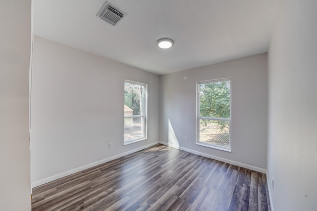 spare room with wood-type flooring and plenty of natural light